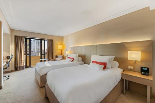 a hotel room with two beds and a desk at InterContinental São Paulo by IHG in Sao Paulo