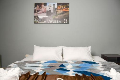 a bedroom with a bed with a poster on the wall at Hotel Villa Colonia in Marinilla