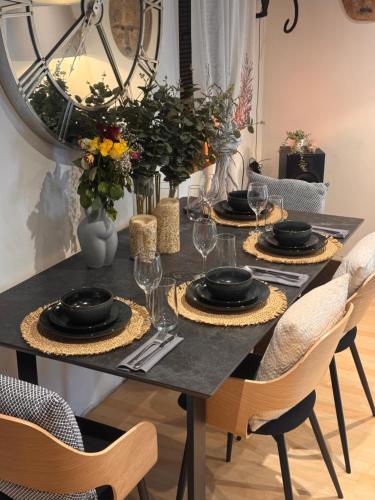 une table de salle à manger avec des assiettes et des verres dessus dans l'établissement Cozy Cottage Coventry self check-in after 3pm, Pets Friendly, à Longford