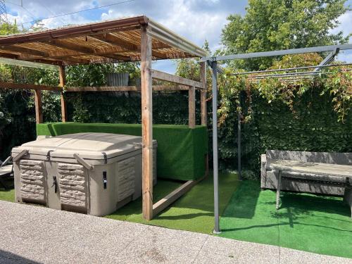 a wooden pergola with a table and a bench at Mambo House in Milan