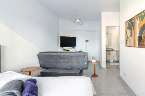 a living room with a couch and a tv at Vista para o Mar & Pé na Areia in São Vicente