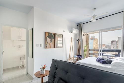 a bedroom with a bed and a large window at Vista para o Mar & Pé na Areia in São Vicente