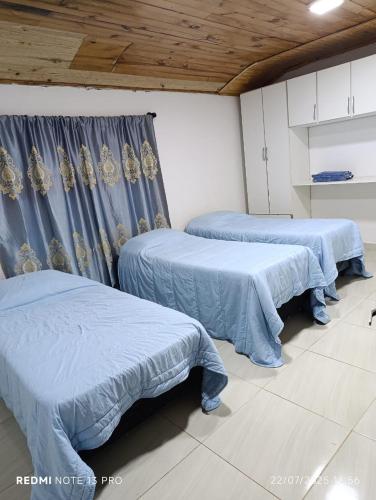 due letti in una stanza con coperte blu di Casa Wilma a Encarnación