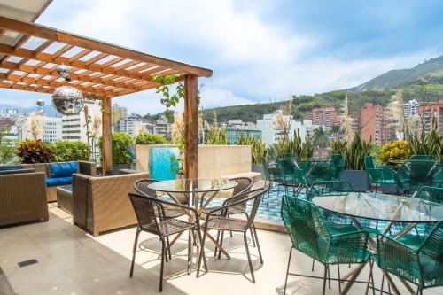a patio with tables and chairs and a view of the city at Faranda Collection Cali, a member of Radisson Individuals in Cali