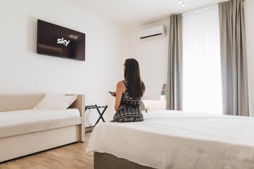 a woman standing in a hotel room looking out the window at Centoquindici Rooms & Suite in Montesilvano