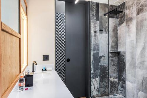 a bathroom with a shower with a tub and a sink at Aloft Tulum in Tulum