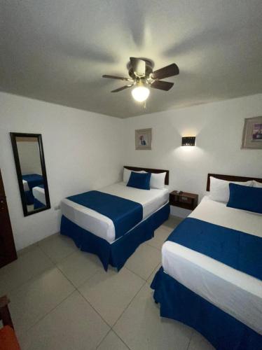 a hotel room with two beds and a ceiling fan at Veranda Hotel in San Pedro Sula