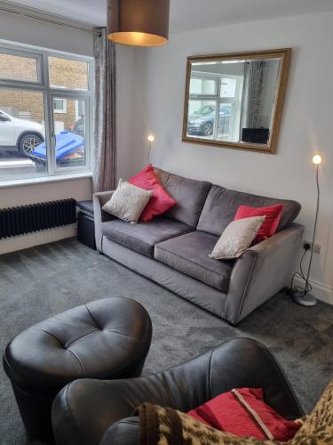 a living room with a couch and a mirror at 3 Bedroom House By The Sea, Deal Centre in Deal