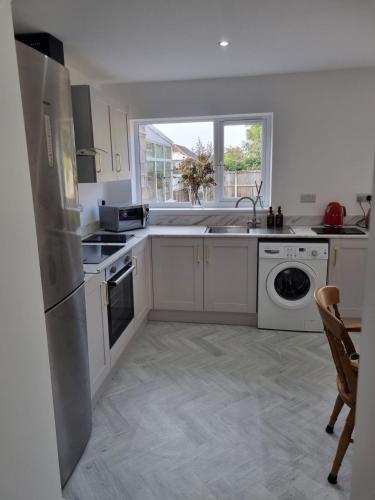 a kitchen with white cabinets and a dishwasher at 3 Bedroom House By The Sea, Deal Centre in Deal