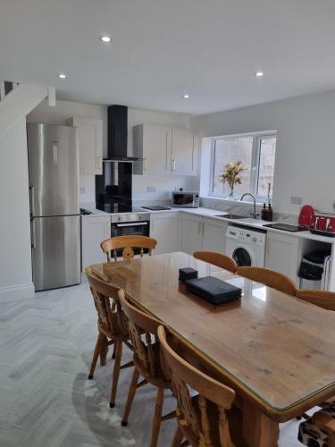 a large kitchen with a wooden table and chairs at 3 Bedroom House By The Sea, Deal Centre in Deal