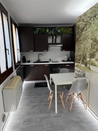 a kitchen with a white table and chairs at City Garden in Rovigo