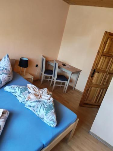 a bedroom with a blue bed and a desk at Ubytovanie u Ladislava in Vrbov