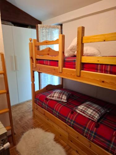2 literas en una habitación con alfombra en Petit Maison - Valtournenche, en Valtournenche