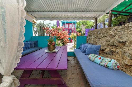 a patio with blue and purple furniture and a table at Mammaloe in Oranjestad