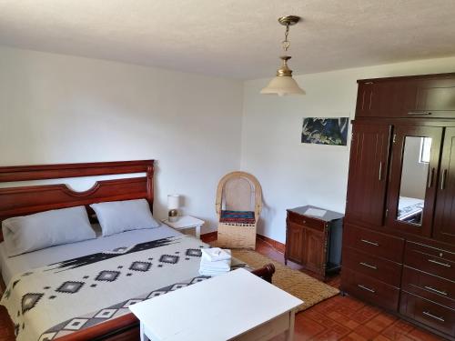 a bedroom with a bed and a dresser at Pishku Wasi in Quito