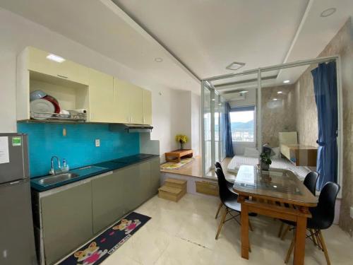 a kitchen with a table and a sink and a room at Mường Thanh Viễn Triều - Hồ Tiên Apartment in Nha Trang