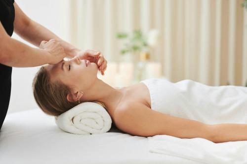 a woman laying on a bed getting a massage at Hotel Bristol, A Luxury Collection Hotel, Warsaw in Warsaw