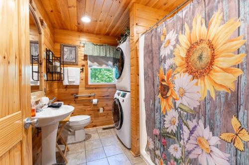 a bathroom with a washer and dryer in a wooden house at Wildflower Cabin with a private hot tub in Bryant