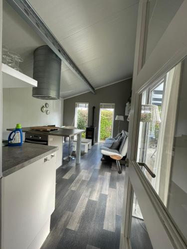 a kitchen and living room with a table and a couch at Chalet op Camping in het Drents Friese Wold in Oude Willem