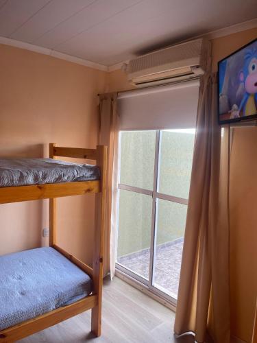 a bedroom with a bunk bed and a window at Las Palmeras de Lavalle in San José