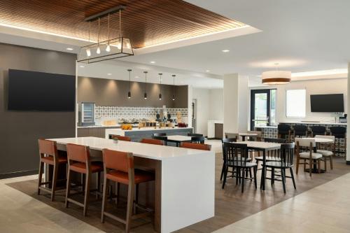 an open kitchen and dining area with tables and chairs at TownePlace Suites by Marriott Lancaster in Lancaster
