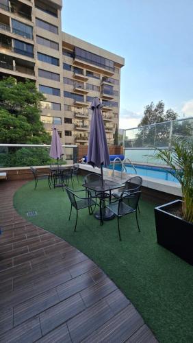 a patio with tables and umbrellas on the grass at Residence Polanco, Security24h, Balcony, Pool, Gym, CarPark in Mexico City