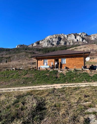 a log cabin in the middle of a field at Odmor pod Mucnjem in Ivanjica