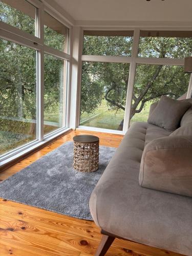 a living room with a couch and large windows at The Budim House in Berane