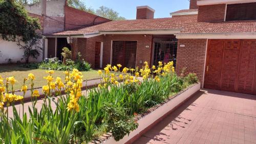 einen Garten mit gelben Blumen vor einem Haus in der Unterkunft DepartamentoVM N2 in Villa Mercedes