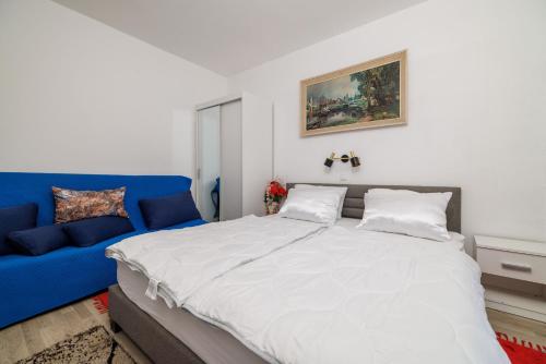 Un dormitorio con una cama grande y un sofá azul. en Apartment Vera, en Kampor