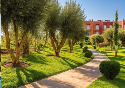 a path in a park with trees and a building at Vizir 301 in Marrakech