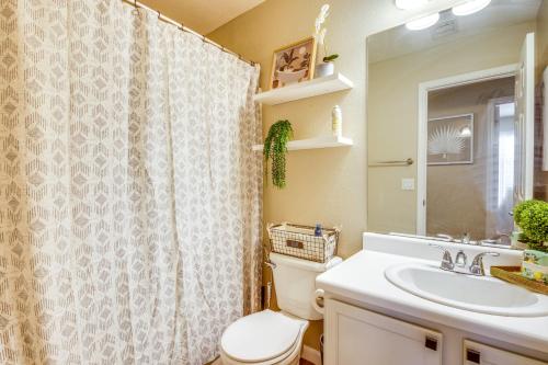 a bathroom with a shower curtain and a toilet and a sink at Fenced-In Pool and Patio Gilbert Home! in Gilbert
