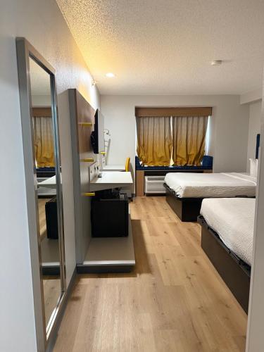 a room with two beds and a sink and a mirror at Microtel Inn & Suites by Wyndham Sioux Falls in Sioux Falls