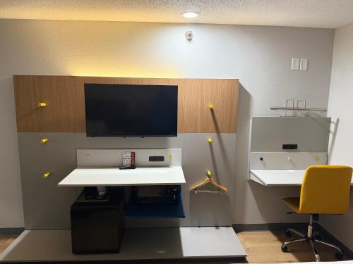 a office with a desk and a tv on a wall at Microtel Inn & Suites by Wyndham Sioux Falls in Sioux Falls