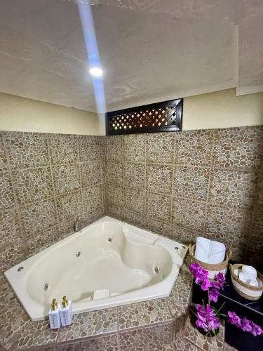 a bathroom with a bath tub in a room at Ara Ambigua Lodge in Sarapiquí