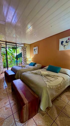 a room with three beds in a room at Ara Ambigua Lodge in Sarapiquí