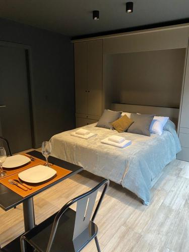 ein Schlafzimmer mit einem Bett und einem Tisch mit 2 Stühlen in der Unterkunft Edificio Pantera - monoambiente 7 in San Martín de los Andes