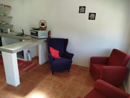 a living room with a table and a chair and a couch at Casas do Montinho in Melides