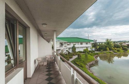a balcony with chairs and a view of a river at Viesnīca Garden in Tīnūži