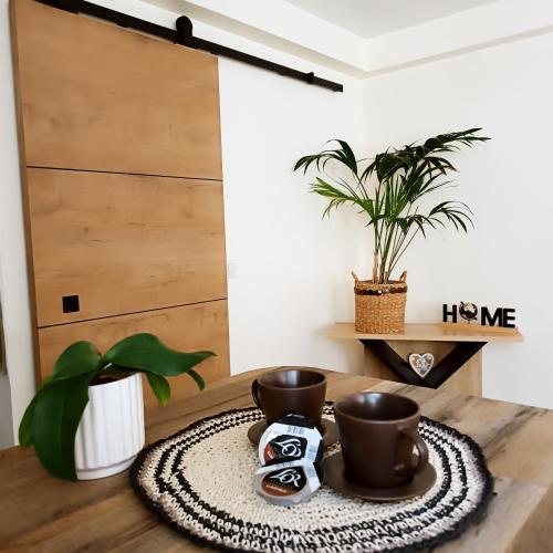 une table avec deux tasses et une plante en pot dans l'établissement at Chris and Caro's, à Nîmes