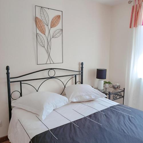 - un lit avec deux oreillers et une photo sur le mur dans l'établissement at Chris and Caro's, à Nîmes