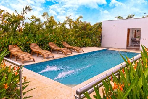 a swimming pool with chairs and plants on a patio at Villa Teresita Campestre in Estación El Salto