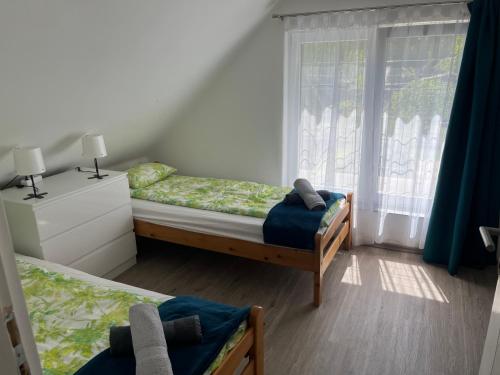 a bedroom with two beds and a window at Napsugár Vendégház Tokaj-Rakamaz in Rakamaz