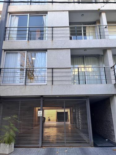 an apartment building with a garage with a gate at Temporary Rental in Chivilcoy