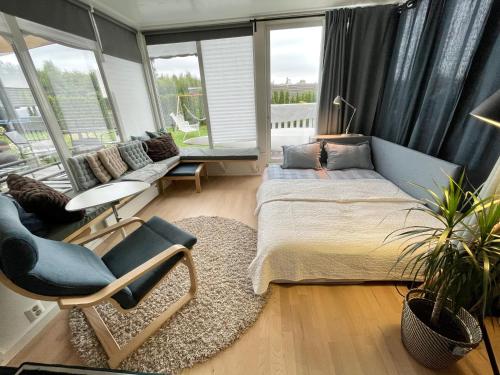 Un dormitorio con una cama, una silla y un sofá. en Floien City Apartment -Free parking, en Bergen