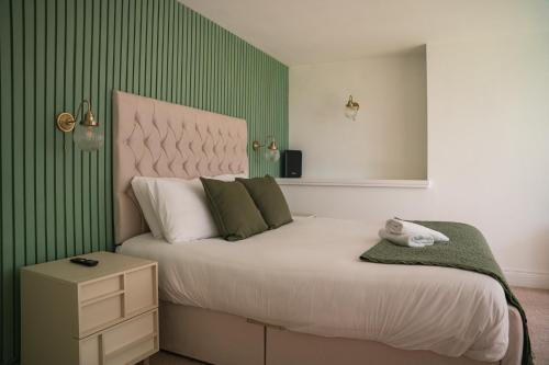 a bedroom with a large bed with green stripes at The Brambles Retreat in the Mournes in Annalong