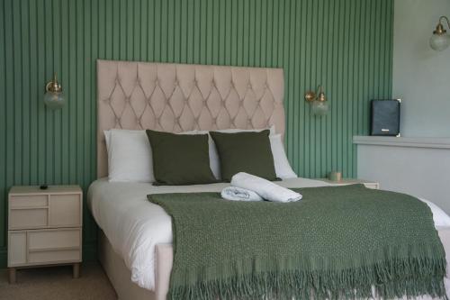 a bedroom with a large bed with green walls at The Brambles Retreat in the Mournes in Annalong