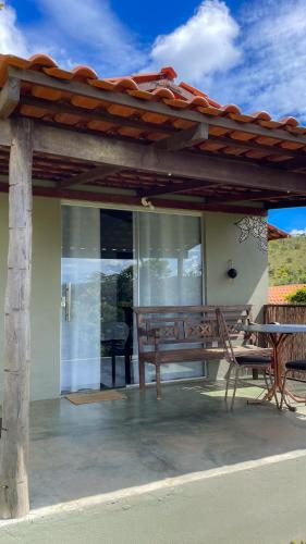 a patio with a wooden bench and a table at Catavento Pousada in Alto Paraíso de Goiás