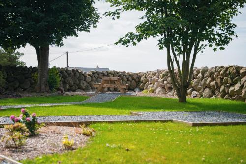 a picnic table in a yard with a stone wall at The Brambles Retreat in the Mournes in Annalong