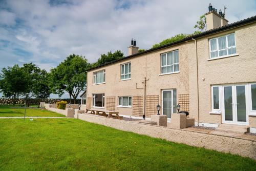 a large brick building with benches in front of it at The Brambles Retreat in the Mournes in Annalong